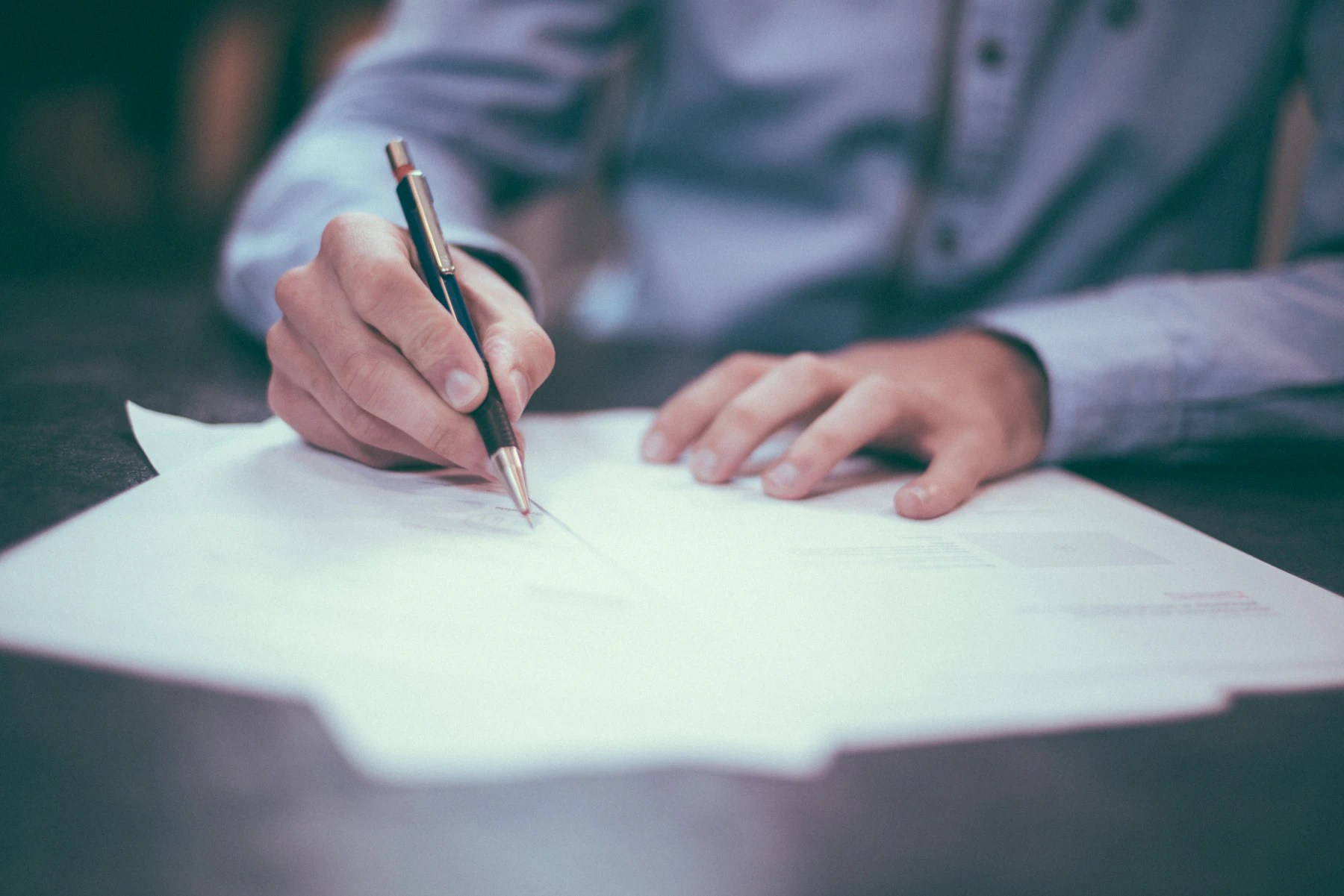 Firma di un documento su una scrivania